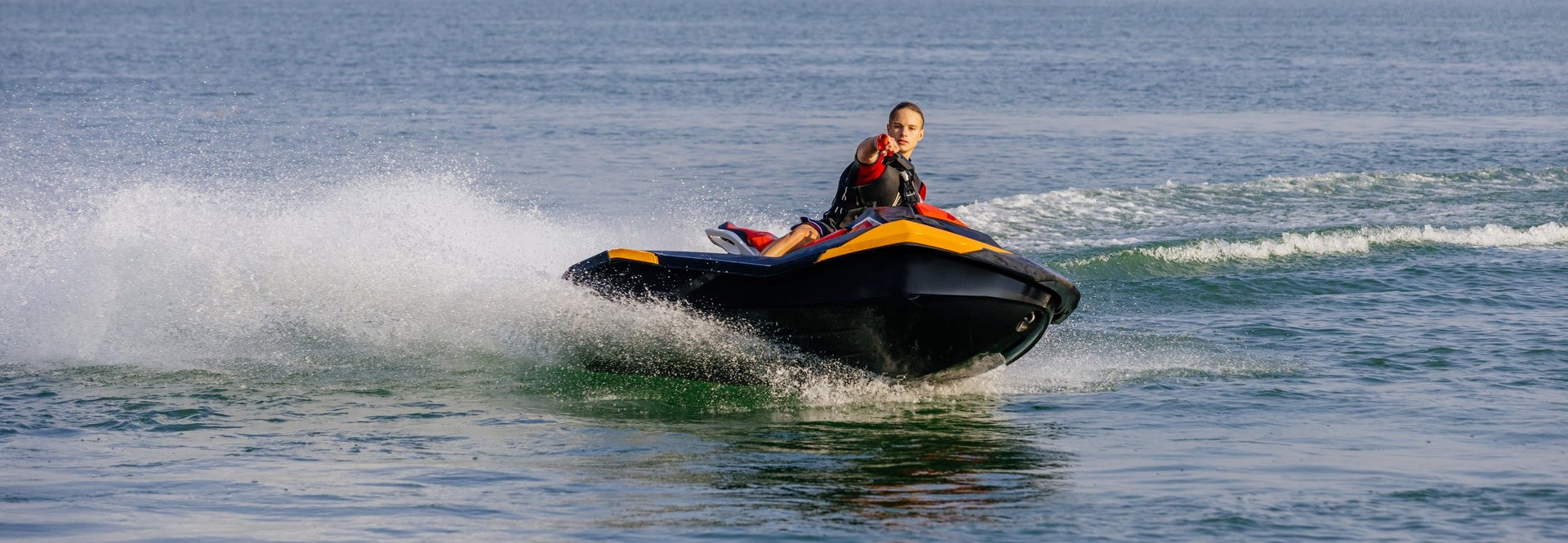 Young man speeding on jet ski under bright Miami sun