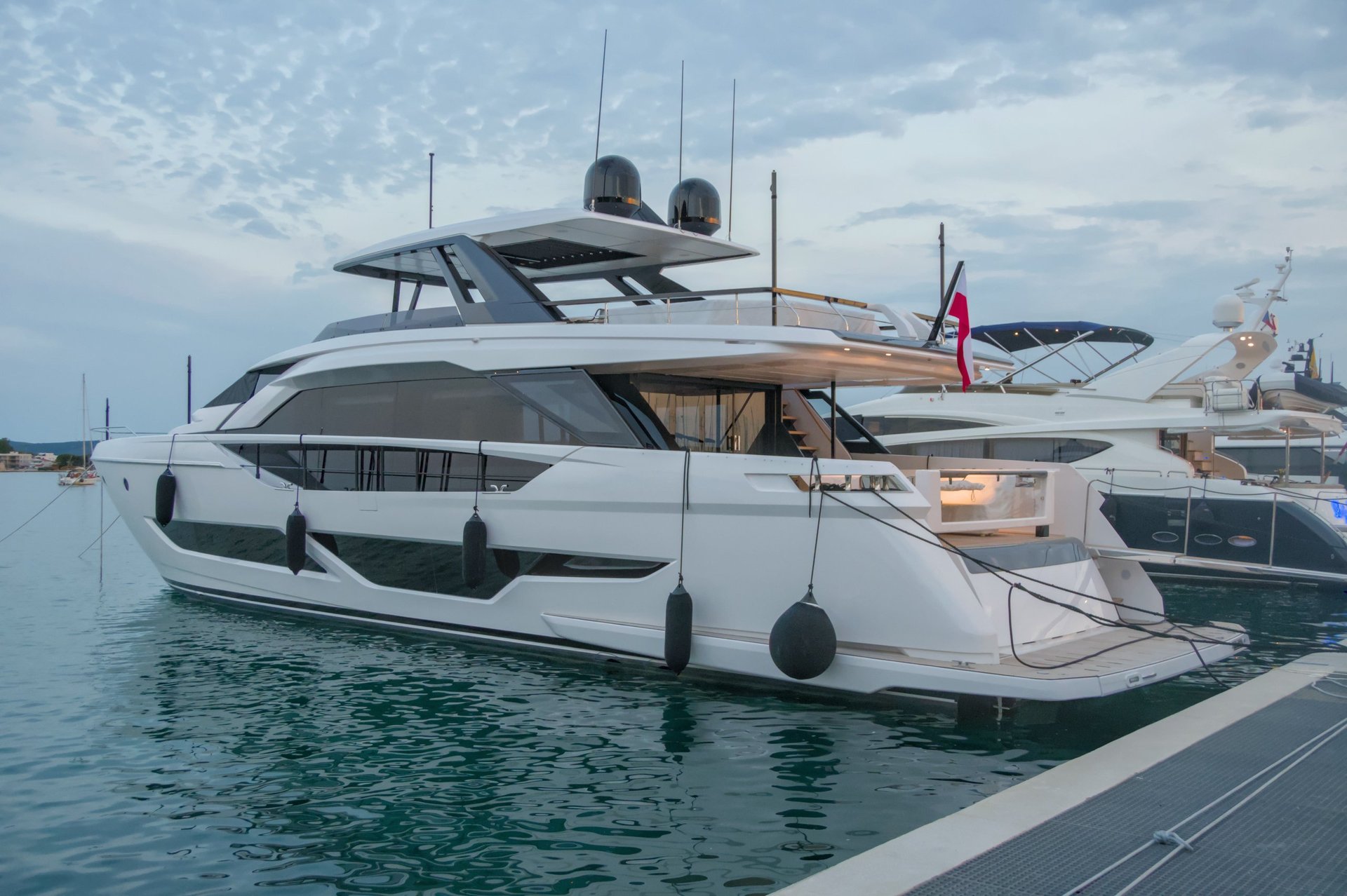 Luxury white motor yacht moored at marina with Miami skyline in background